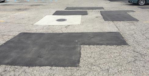Asphalt patchwork repair across a Connecticut parking lot