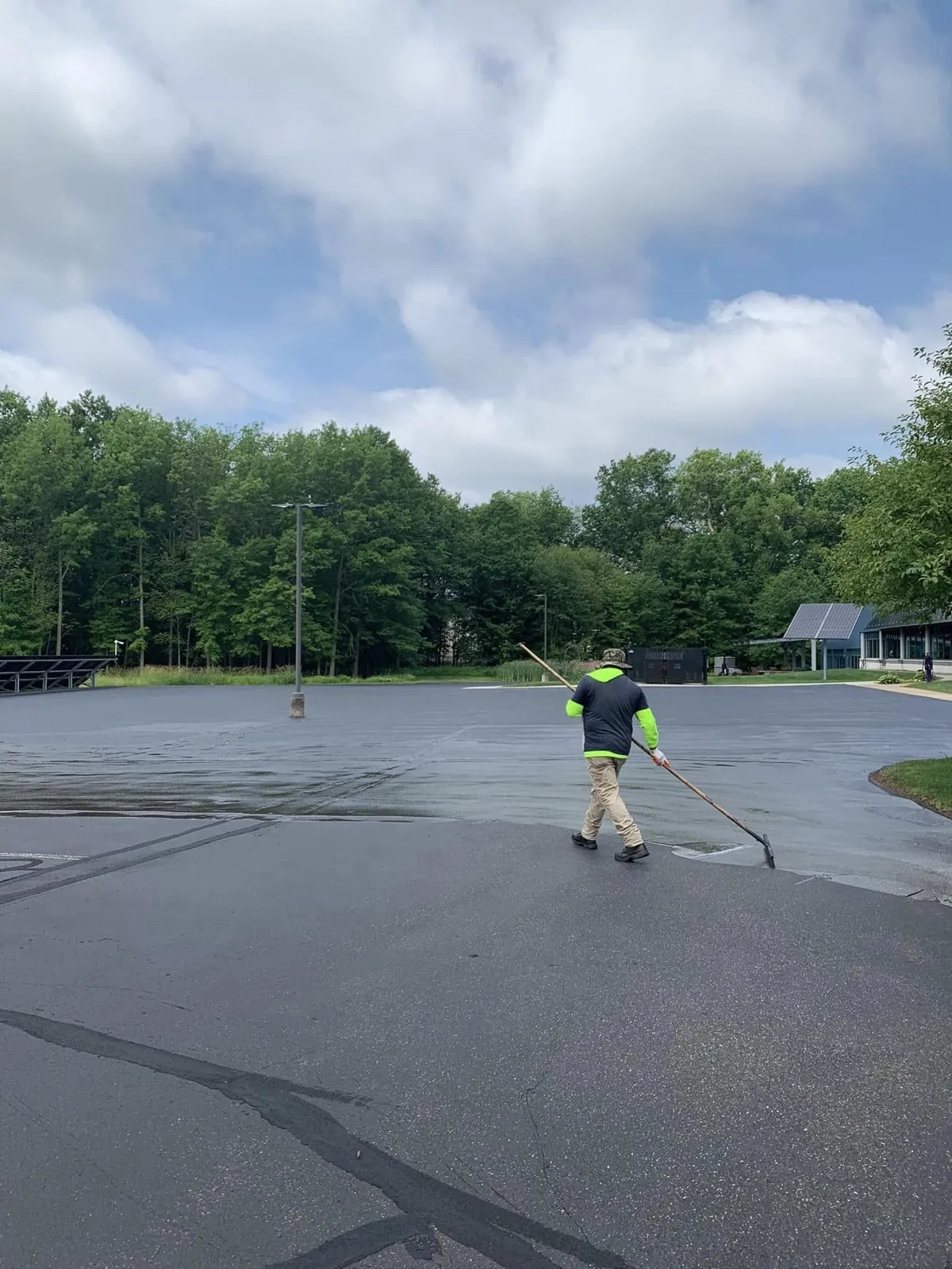 Pavement Protectors crew squeegeeing sealer across a commercial lot in Connecticut
