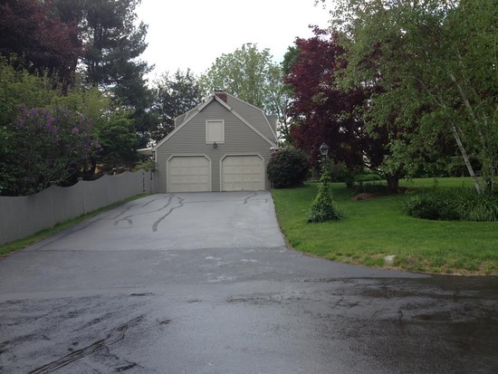 Freshly sealcoated driveway leading to a two-car garage in Guilford, CT