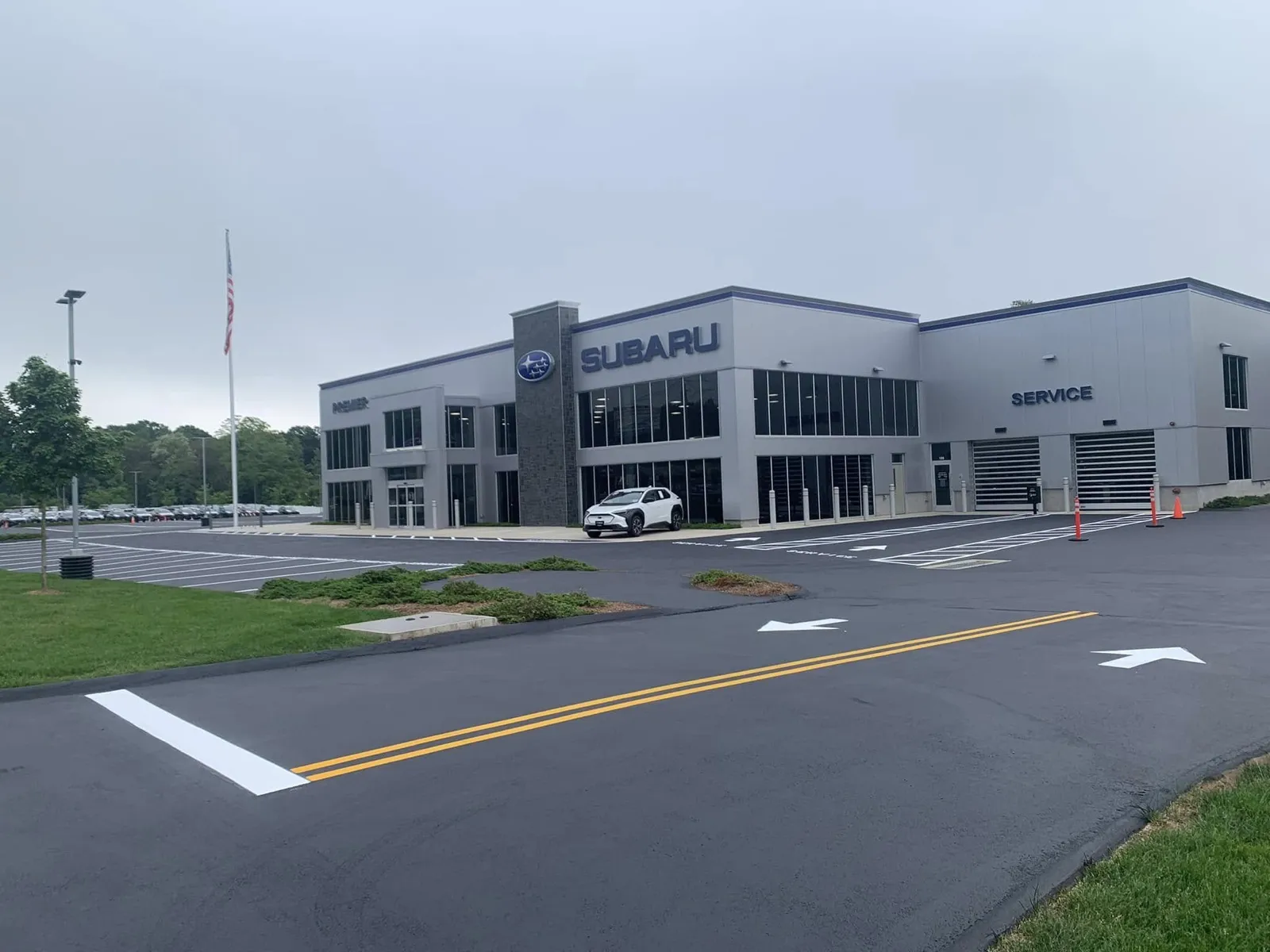 Sealcoated and striped Subaru dealership parking lot with directional arrows in Connecticut